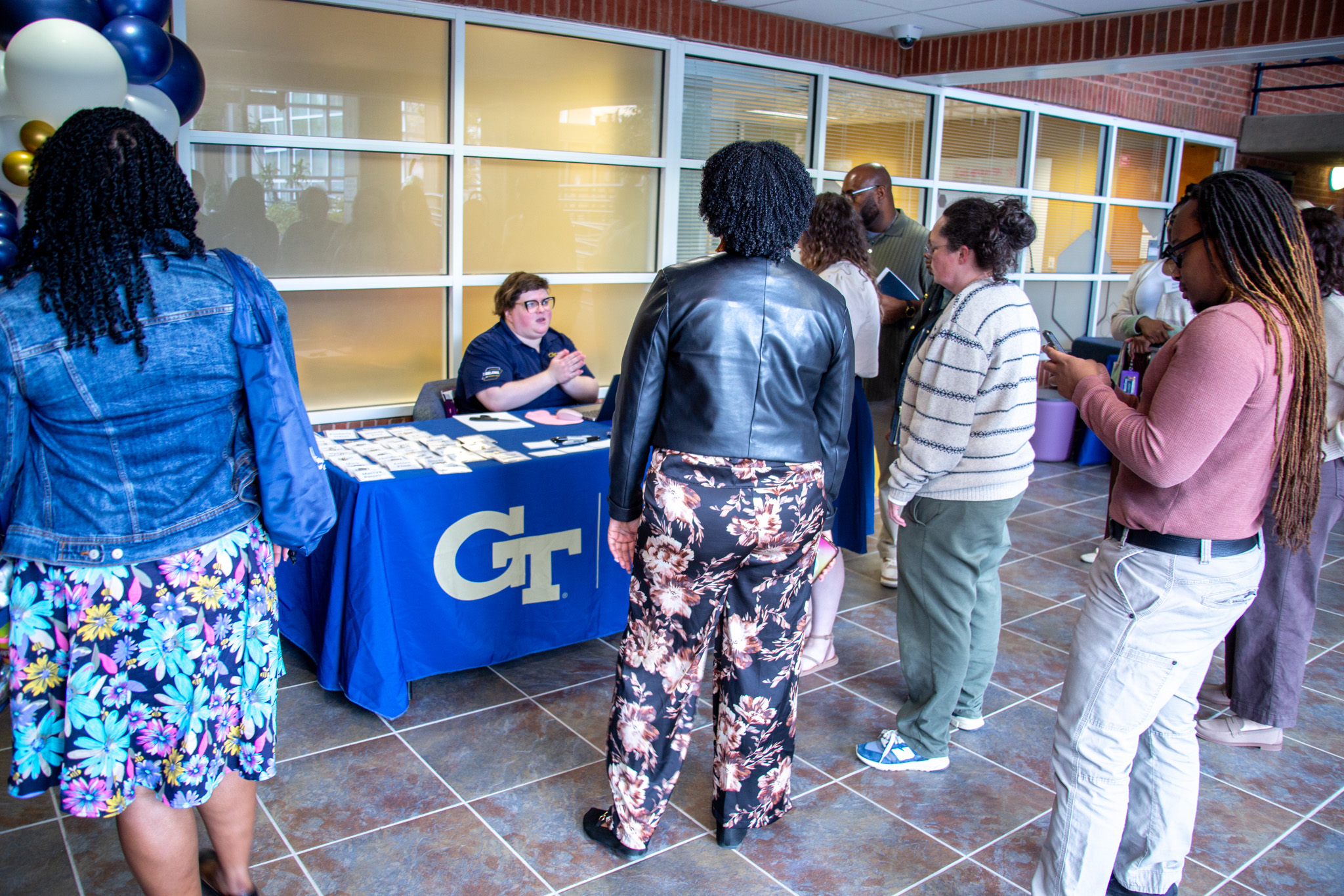 A person sits behind a check-in table facing a group