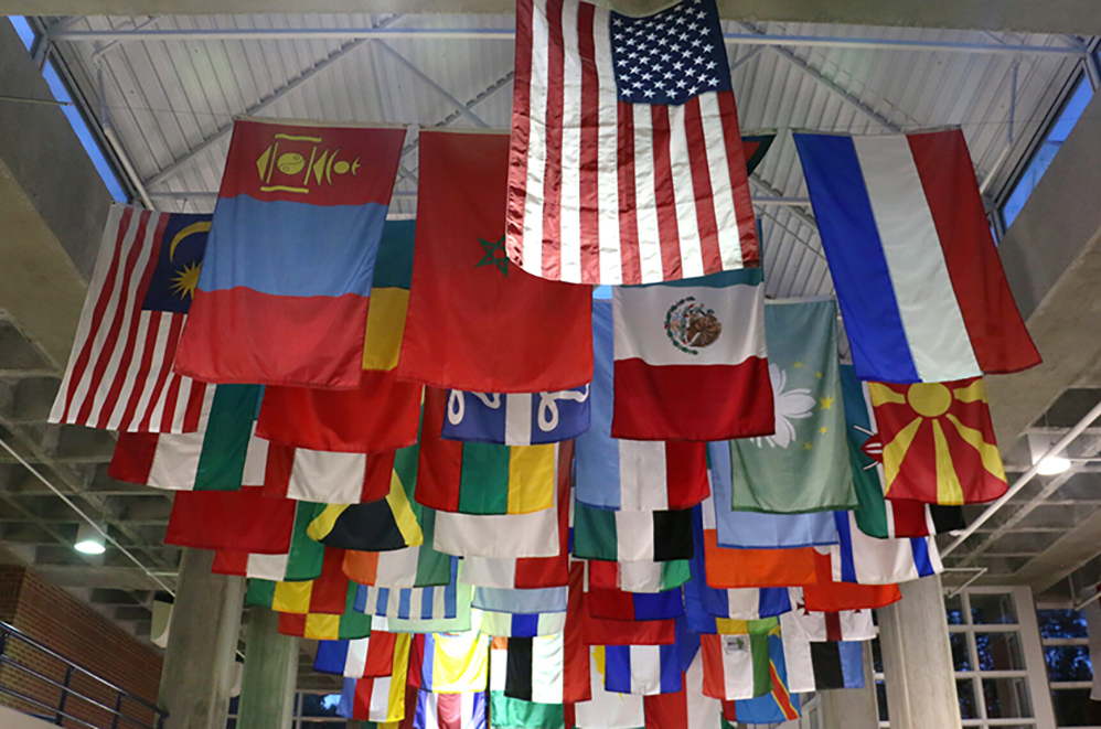 Flags from multiple countriesn hang from a ceiling