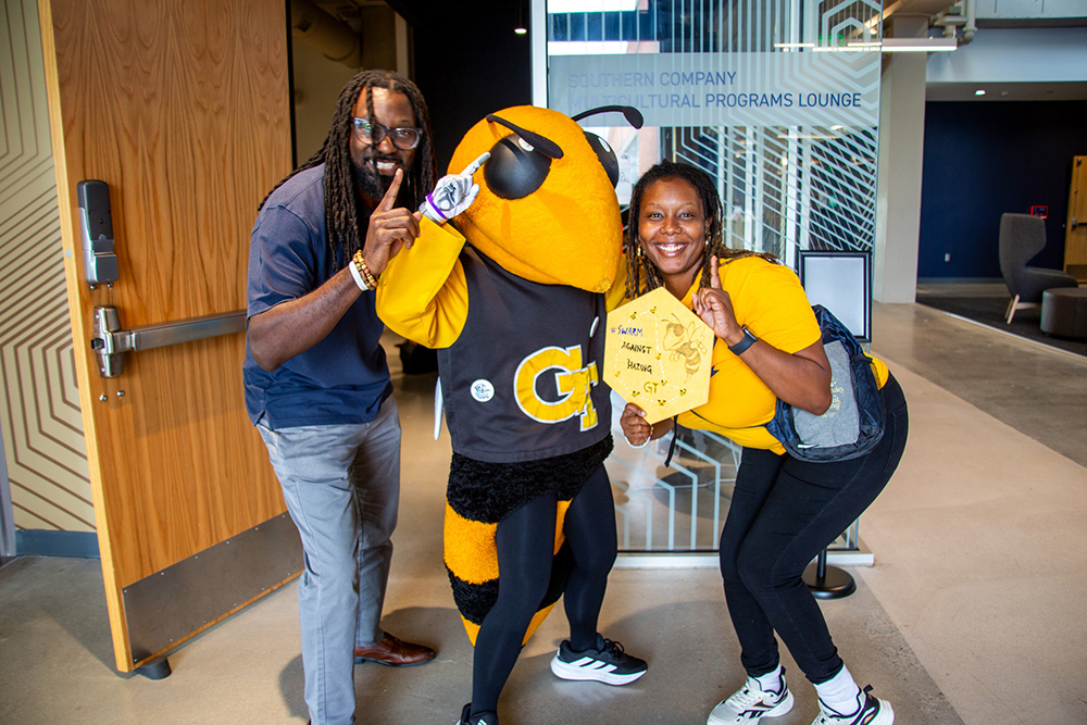 Two people and a Yellow Jacket team mascot